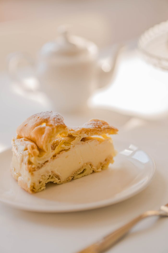 A delicious slice of homemade Karpatka cream pie on a white plate with elegant background.